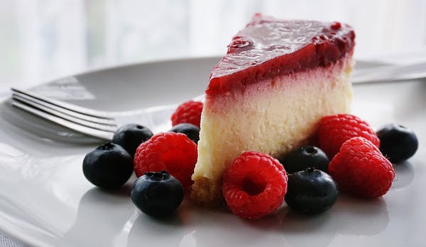 A slice of cheesecake wit some fresh berries
